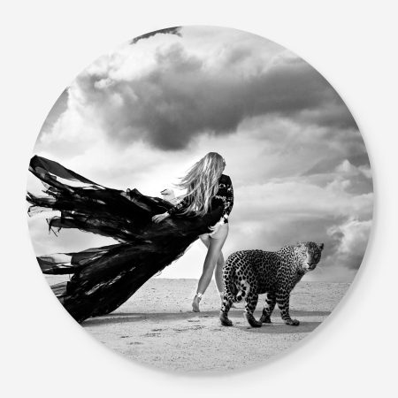 Woman walking in the desert with a leopard
